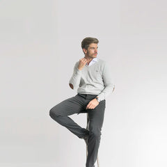 Hombre sentado con suéter gris y pantalón negro. 