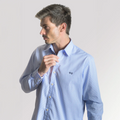 Hombre de perfil con camisa de cuadros azul claro.