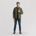 Hombre sobre fondo blanco con chaqueta bomber verde militar jeans y camisa negra. 